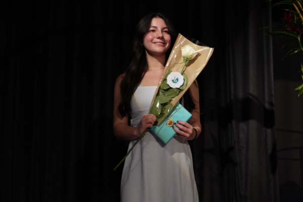 Juniors Arwen Law pose with a IB notebook and flowers in hand after recieiving their pin.