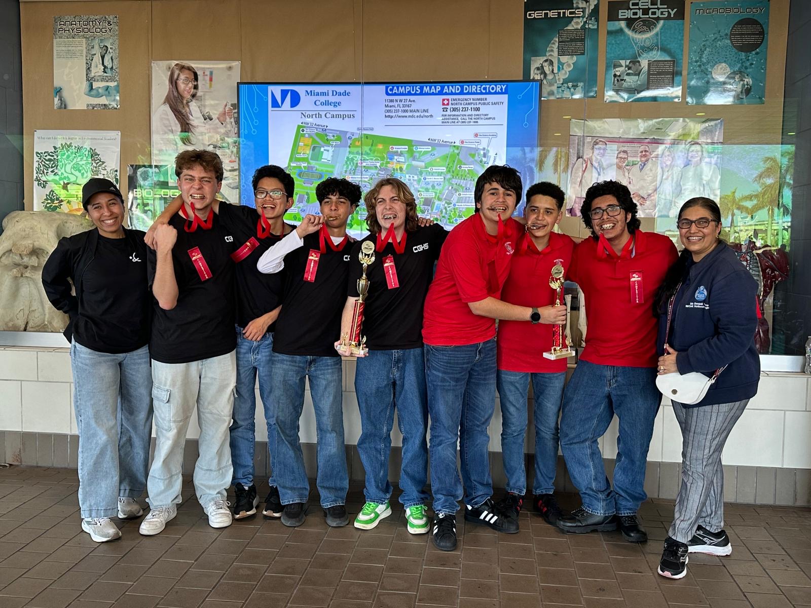 After working hard, SECME students pose and bite their medals with their middle school science teacher. (Courtesy of Nicolas Theye)