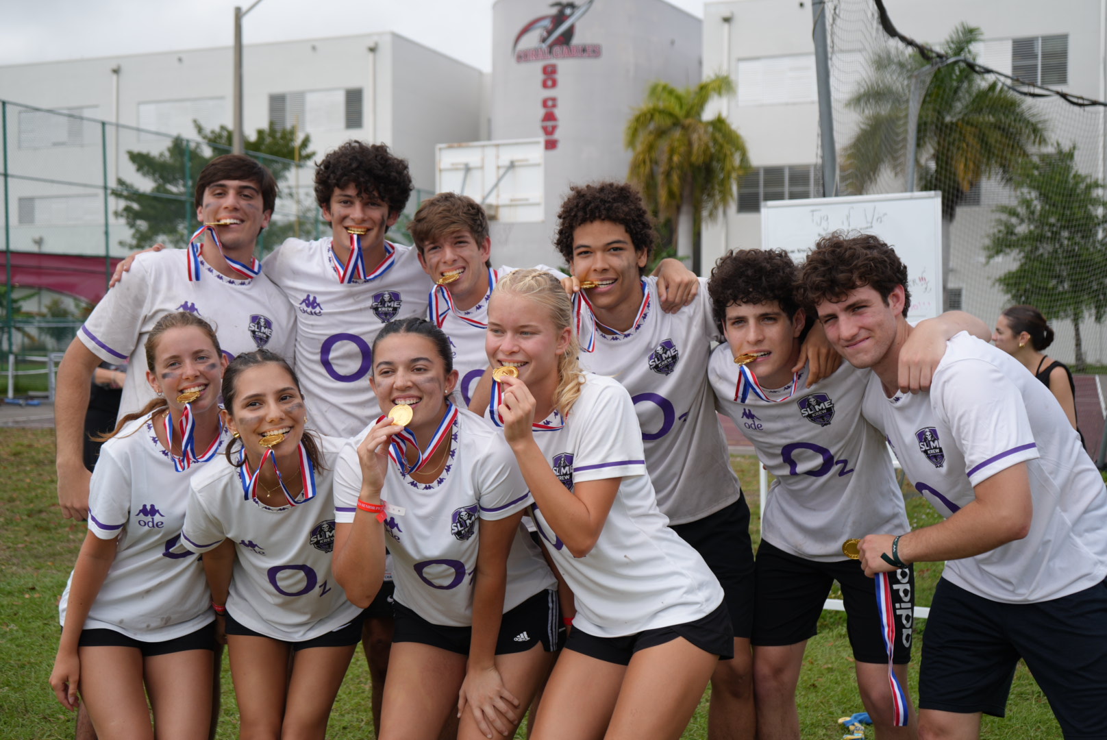 Participating in the longstanding Olympic tradition, Team Sl1me poses for their victory photo by biting their newly earned medals